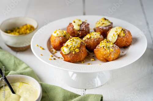 Frittelle with Pistachio Cream on Cake Stand photo