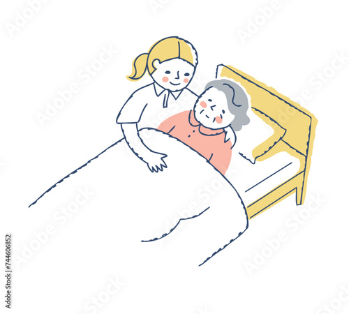ベッドに寝ているシニア女性と介護している女性