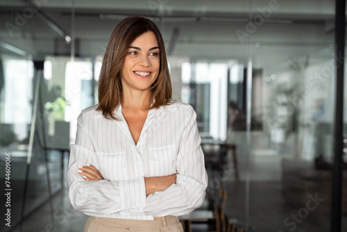 Portrait of beautiful hispanic senior business woman with crossed arms smiling. European or latin confident mature good looking middle age leader female businesswoman on office background, copy space. Free Download Portrait of beautiful hispanic senior business woman with crossed arms smiling. European or latin confident mature good looking middle age leader female businesswoman on office background, copy space. - GFXLoad