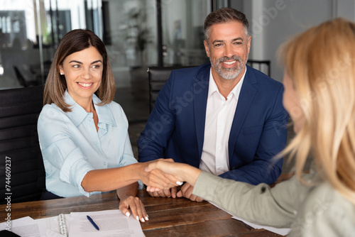Quadro em tela Mature Latin businesspeople of woman and European business man shaking hands with colleagues, partners or employees, signing a contract