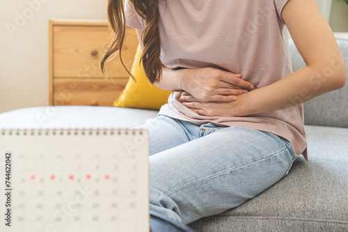 Menstruation, period cycle day of monthly, hurt asian young woman, female hand in stomach ache, suffer from PMS premenstrual, belly or abdomen pain on bed at home. Health problem Inflammation in body.