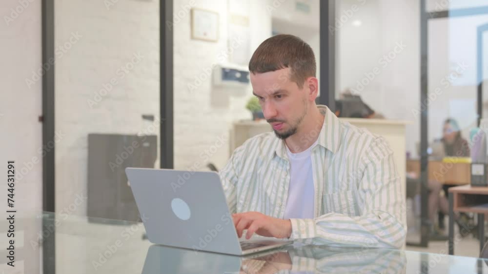 Creative Young Man Working on Laptop in Office Creative Young Man Working on Laptop in Office