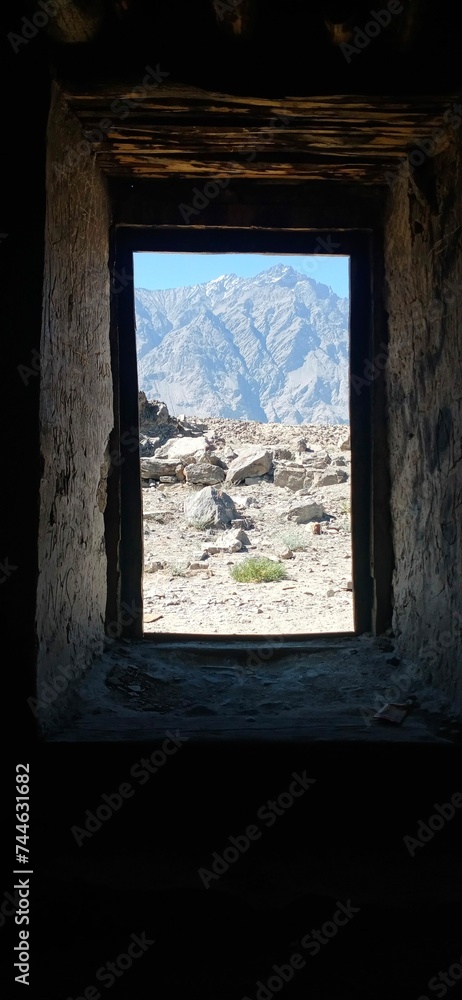 Scenic Mountain Range through Rustic Window of Kharpocho Fort, Skardu, Pakistan Scenic Mountain Range through Rustic Window of Kharpocho Fort, Skardu, Pakistan