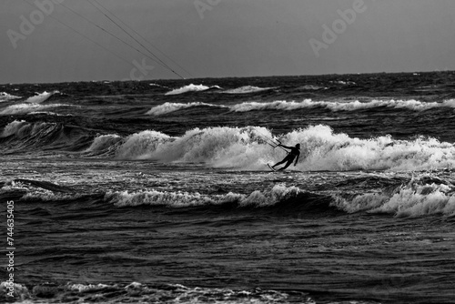 kite surfers ride the waves. Winter sport with high waves and many dangers. Wind and wave speed. Men and women do extreme sports People water sport 