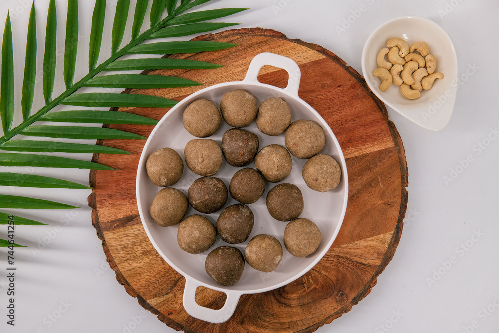 Fresh home made urad dal and millet laddu isolated and decorated. Locally called Urad Dal Ladoo, Ulundu urundan, Ulundu laddu, Kambu laddu. Selective focused millet ladoo. Fresh home made urad dal and millet laddu isolated and decorated. Locally called Urad Dal Ladoo, Ulundu urundan, Ulundu laddu, Kambu laddu. Selective focused millet ladoo.