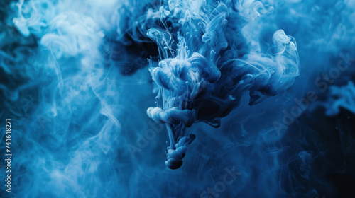 Blue paint drop mixing in water towards to camera. Ink swirling underwater. Cloud of ink isolated on black background. Abstract smoke explosion effect with particles. photo