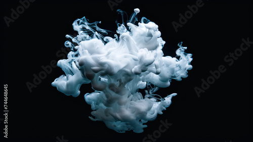 White paint drop mixing in water towards to camera. Ink swirling underwater. Cloud of ink isolated on black background. Abstract smoke explosion effect with particles.