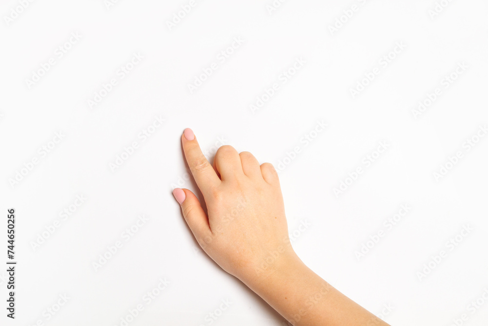 Woman's hand points with finger at empty space on light background Woman's hand points with finger at empty space on light background