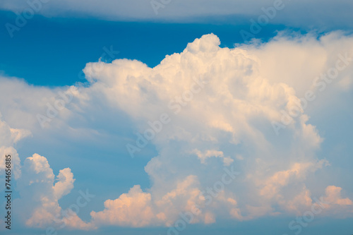 beautiful large white and pink clouds in the blue sky during sunset time