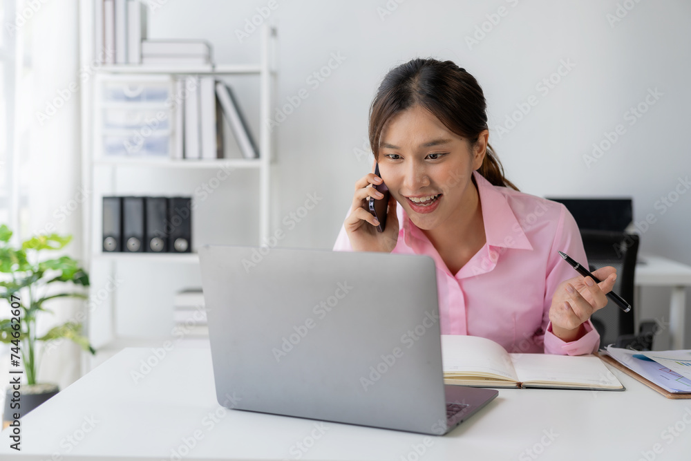 Annual summary report, laptop and paper placed at desk, Asian woman working online and planning financial data with laptop and succeeding with excited and happy face Annual summary report, laptop and paper placed at desk, Asian woman working online and planning financial data with laptop and succeeding with excited and happy face