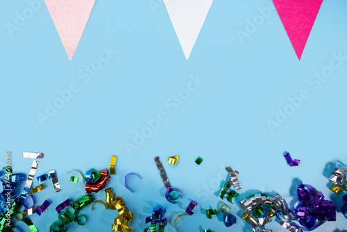 Anniversary confetti and holiday flags on blue background, celebratory decorations, festive pennants