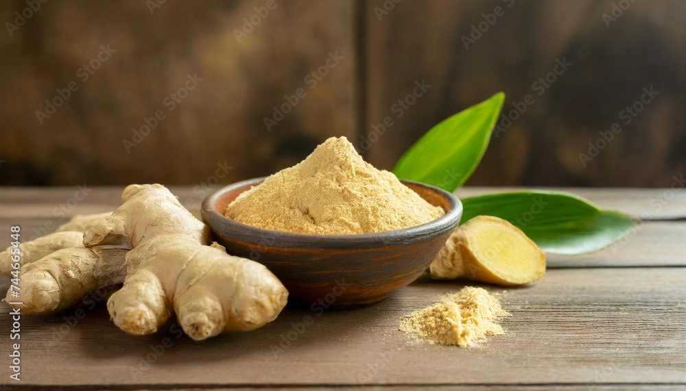 Fresh ginger roots and ginger powder in bowl on wooden table. Fresh ginger roots and ginger powder in bowl on wooden table.
