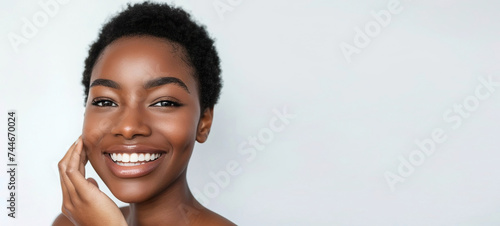 Portrait of a smiling African American woman looking into the camera while touching her healthy flawless glowing skin after a spa treatment, on an isolated white background. Generated AI