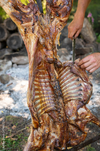 Grilled Lamb, traditional way of cooking sheep meat in Argentina. Cutting it and serving it from the grill.