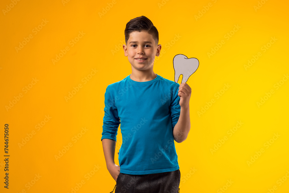 Child boy holding papercraft tooth. Dental health concept Child boy holding papercraft tooth. Dental health concept