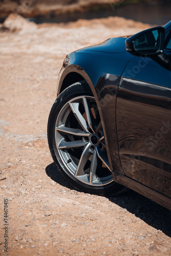 Close-up view of wheel of sports car at the gravel road