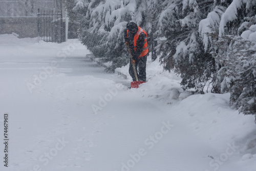 snow removal man removes snow with shovel.