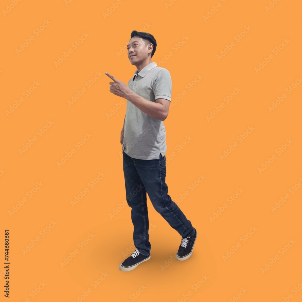 Full length image of cheerful man in his 30s wearing t-shirt and jeans showing finger while posing and smiling isolated on orange background Full length image of cheerful man in his 30s wearing t-shirt and jeans showing finger while posing and smiling isolated on orange background