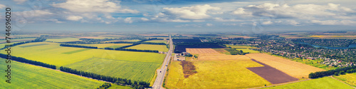 Sunny day in the countryside. Rural landscape in daylight. Aerial view of the countryside, country road, fields, and beautiful cloudy sky