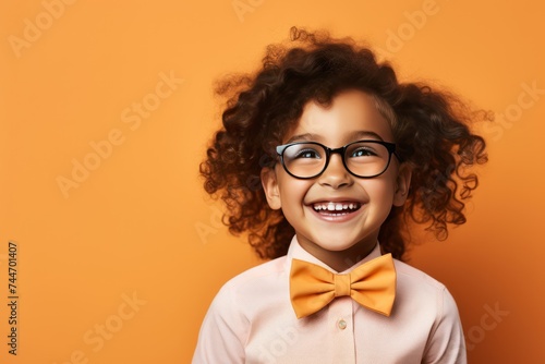 Adorable 5YearOld Girl in Big Eyeglasses and Bowtie on Pastel Background photo