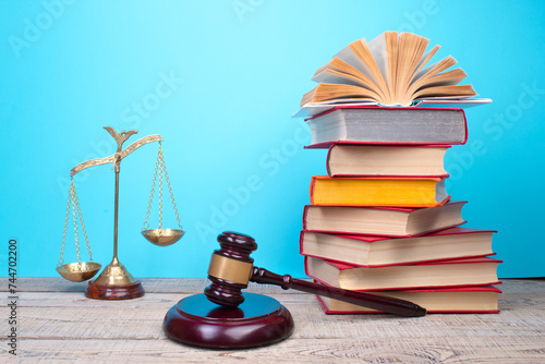 Law concept - Open law book, Judge's gavel, scales, Themis statue on table in a courtroom or law enforcement office.