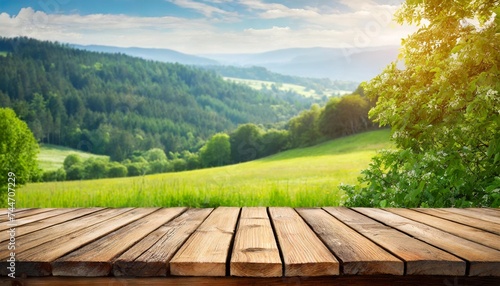 empty wooden table with a serene meadow and trees © Nayeli