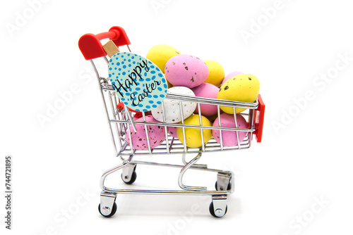 Shopping supermarket cart with red handle with colorful glitter easter eggs isolated on a white background. Happy easter! Purchase of products for the holiday.