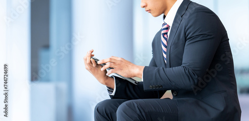 スマートフォンを使う若い外国人男性ビジネスマン photo