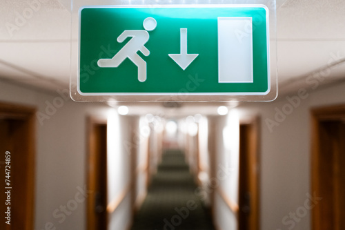 Fotografia Shallow focus of a generic Fire Escape sign seen hanging from the ceiling of a hotel lobby in the UK