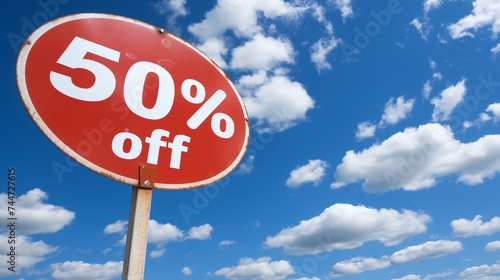 a red sign with the words 50% off under a blue sky with clouds in the background