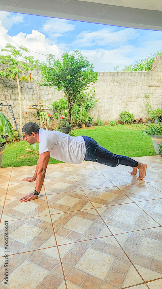 Man practicing calisthenics exercises at home