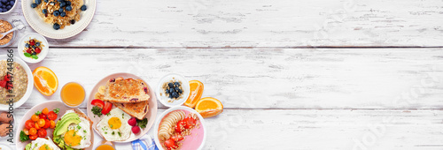Healthy breakfast or brunch corner border on a white wood banner background. Above view. Avocado toast, smoothie bowls, oats, yogurt and various nutritious foods.
