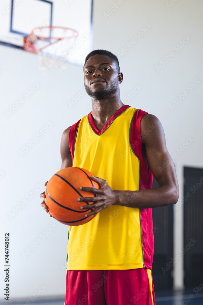 Confident African American man holds a basketball in a gym Confident African American man holds a basketball in a gym