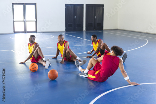Diverse basketball players take a break on the court photo