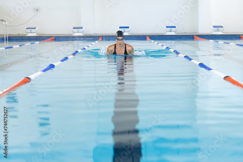 Caucasian female athlete swimmer swimming laps in a pool photo