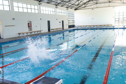 An indoor swimming pool awaits swimmers, with copy space