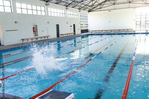 An indoor swimming pool awaits swimmers, with copy space photo