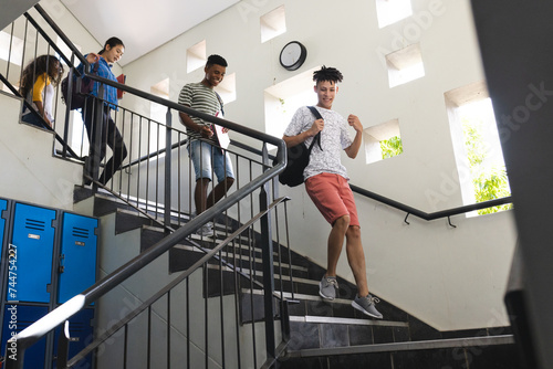 Teenage biracial boys and teenage girls in a high school stairwell photo