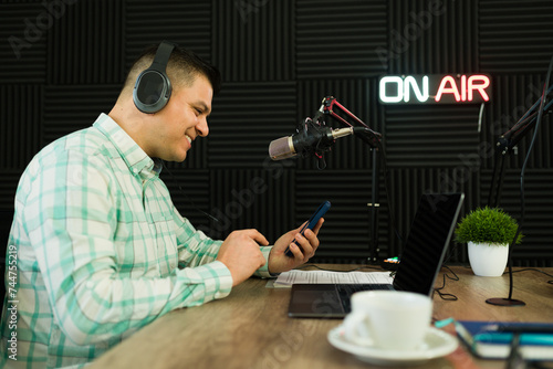 Fotografía Happy man reading social media messages on air during a radio show or podcast