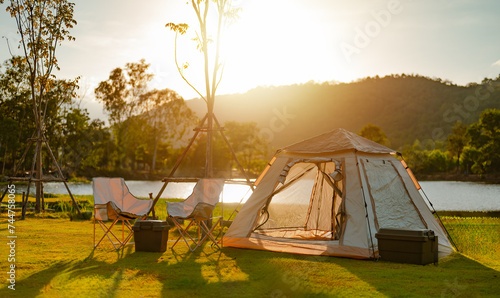 nature, tent, camp, landscape, summer, travel, adventure, mountain, sunset, camping. landscape is campground has campfire, tent, armchair near the lake with sunrise at mountains in the background.