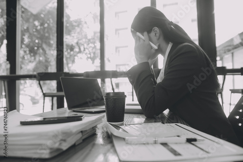 Asian women are stressed while working on laptop, Tired asian businesswoman with headache at office, feeling sick at work, copy space