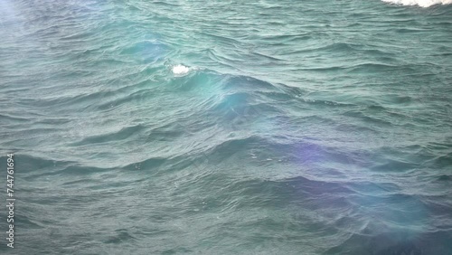 Transparent blue-green sea and white-capped waves. Slow motion photo