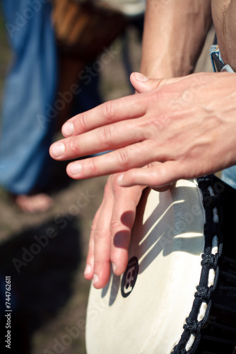 a close up of a person s hands playing a drum