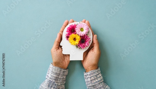 hands holding paper head human brain with flowers self care and mental health concept positive thinking creative mind used for brain