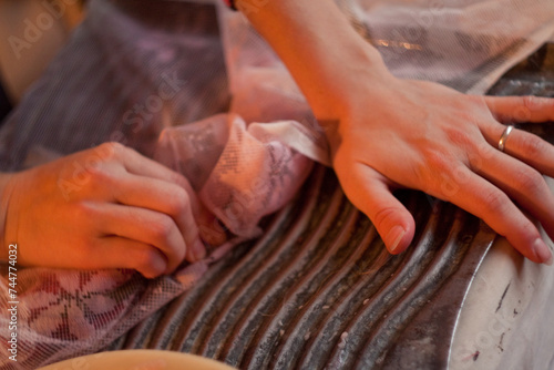 Closeup of hands on fabric, featuring gesture and thumb detail