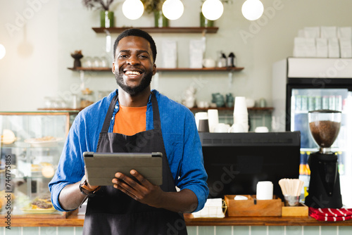 African American man holding a tablet in a cafe, with copy space photo