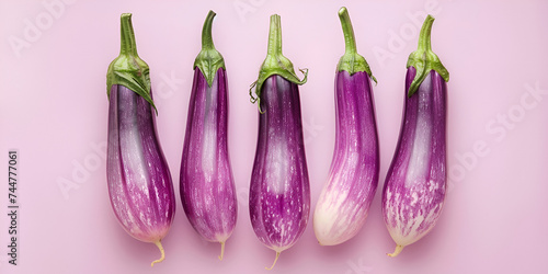 long  brinjals isolated on pink background, Close-up of a pile of colorful eggplant 