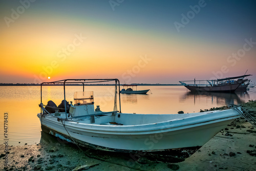 Golden sunrise in Dammam Corniche,Saudi Arabia: Peaceful waters and boats embraced by the morning light. © AFZALKHAN