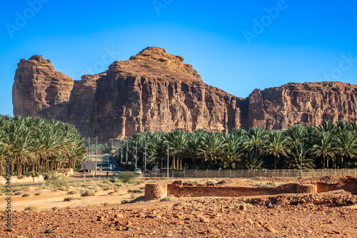 Desert mountains with ruins of Dadan and road with palms, Al Ula, Madain Salih, Saudi Arabia photo