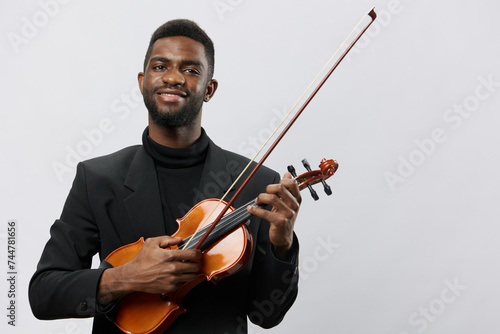 Professional African American musician in formal suit holding violin against white background for musicrelated advertisement photo